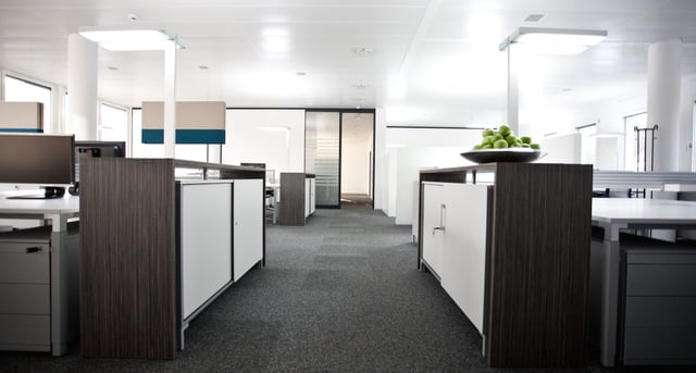 Bürofläche mit Sideboards in Holzoptik, darauf eine Schale grüner Äpfel